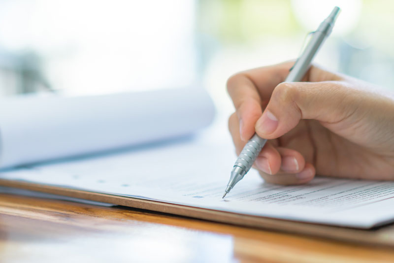 A person filling out a form, OH | Marshall Dental & Aesthetics